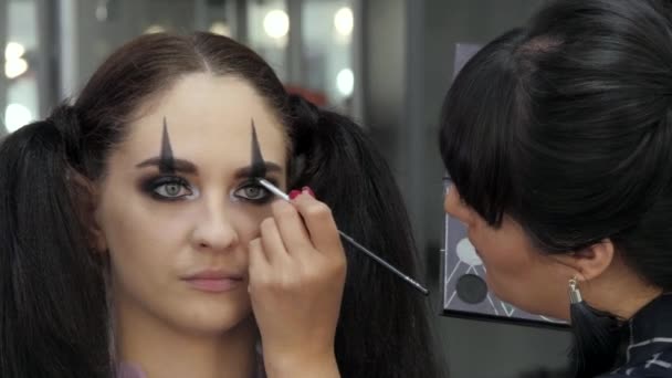 Lehký Halloweenský makeup. Holka v salónu krásy. Používám stylistický vzor na tvář modelu. Práce mistra stylisty. — Stock video