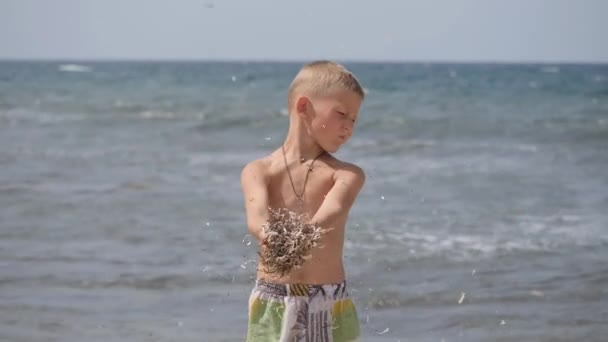 Vacaciones de verano en playa. Emociones de los niños. El niño desarrolla oropel en el viento . — Vídeo de stock