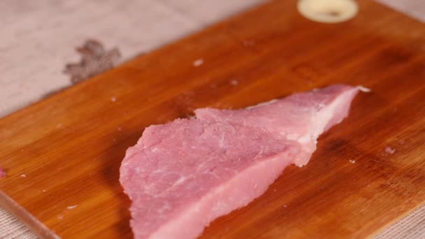 Schweinefleisch steht auf dem Speiseplan. Schweinefleisch in Scheiben geschnitten. Prozess des Zerkleinerns einer Scheibe rotes Fleisch. Metallhammer fällt auf das Fleisch. Stück Fleisch wird auf den Kopf gestellt. Die Hände der Köche waren mit Latexhandschuhen bekleidet. — Stockvideo