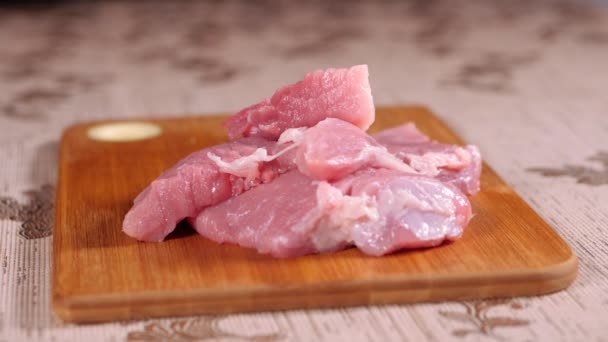 Pieces of meat fall on a wooden Board. Pork is on the Board. Sliced pork meat. — Stok video