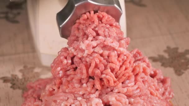 Filling comes out through a meat grinder sieve. Meat grinder close up. Pile of chopped meat. Mincer machine with fresh chopped meat. Process of meat grinding in the kitchen with mincing machine — 비디오