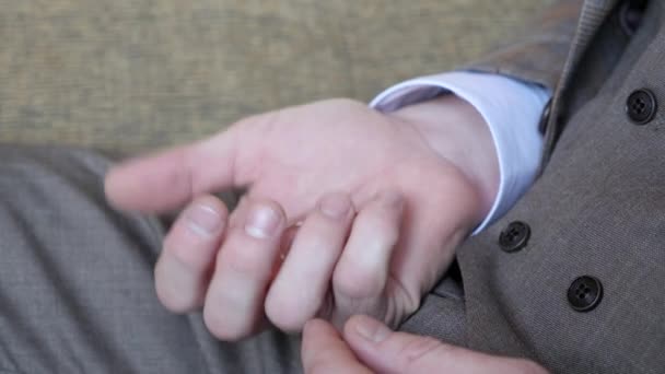 Op de palm van een mensenhand zijn trouwringen. De man knijpt in de ringen. — Stockvideo