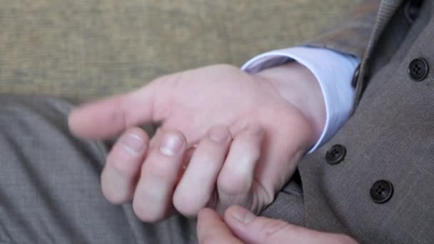 En la palma de la mano de un hombre hay anillos de boda. El hombre aprieta los anillos . — Vídeo de stock