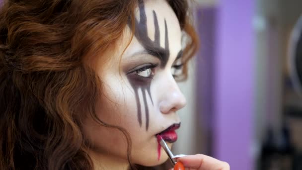 Maquillaje fácil de Halloween. Aplicando maquillaje a la cara. Dibujando sangre roja en la cara de una niña llorando. Un bebedor de sangre . — Vídeos de Stock