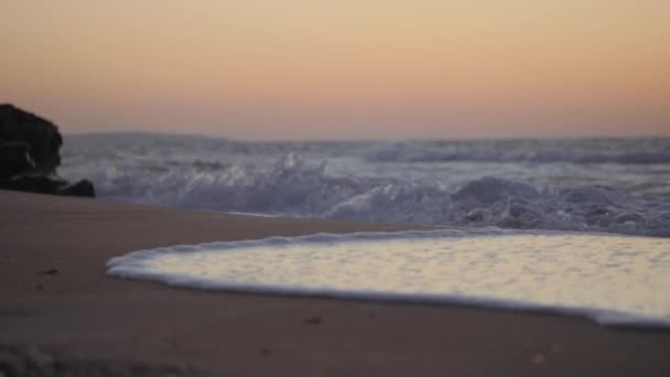 Waves wash over the sandy beach. Water is absorbed into the sand. — 비디오