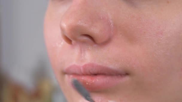 Vorbereitung der Models auf das Make-up. Lippenbehandlung mit Spachtel und Lippenbalsam. Nahaufnahme. — Stockvideo