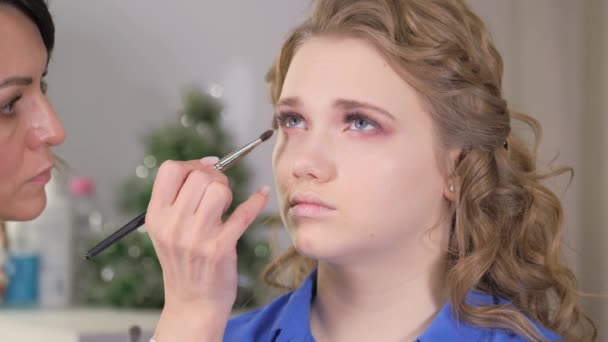 Werk van een make-up artiest. Schaduwen aanbrengen op het ooglid van het modeloog. — Stockvideo