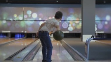 Bowling 'de zaman geçirmek. Pistte paten yapan toplar lobutları devirmek için..