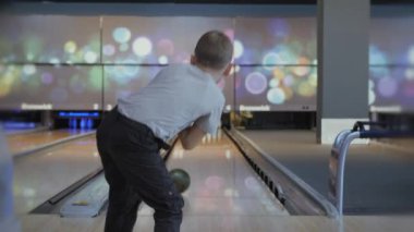 Bowling 'de zaman geçirmek. Pistte paten yapan toplar lobutları devirmek için..