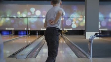 Bowling 'de zaman geçirmek. Pistte paten yapan toplar lobutları devirmek için..