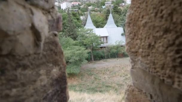 Vista attraverso il muro di mattoni della fortezza. Veduta della città attraverso la scappatoia del castello . — Video Stock