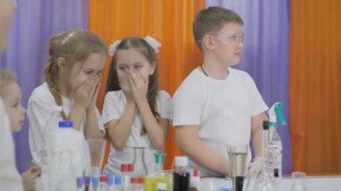 Chemical experiments for children. Fun experiments for children. Children cover their nose from the unpleasant smell.