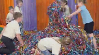 Colored ribbons fly in different directions. Woman emerges from under the coloured ribbons.