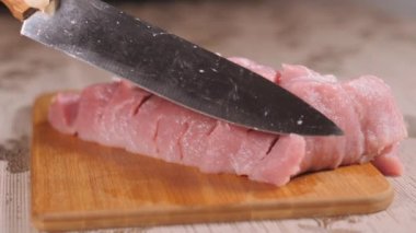 Etin içinden metal bir bıçak geçir. Domuz eti yönetim kurulunda. Dilimlenmiş domuz eti.