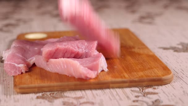 Kawałki mięsa spadają na drewnianą deskę. Wieprzowina jest w zarządzie. Mięso wieprzowe krojone. — Wideo stockowe