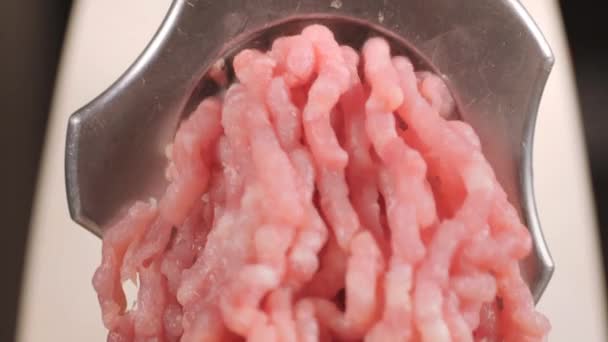 Filling comes out through a meat grinder sieve. Meat grinder close up. Pile of chopped meat. Mincer machine with fresh chopped meat. Process of meat grinding in the kitchen with mincing machine — Stockvideo