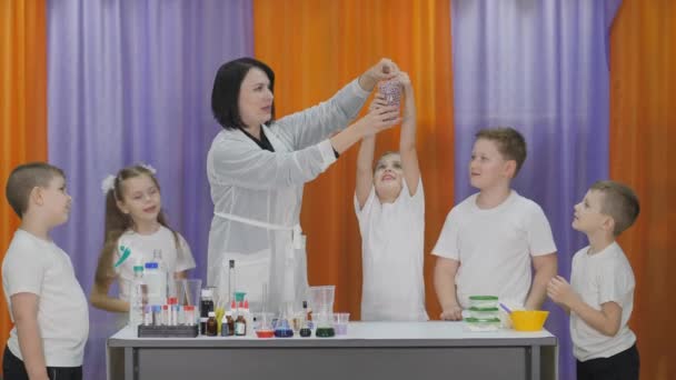 아이들을 위한 화학 실험. 아이들 이유리 에서 구슬을 꺼내자, 그 구슬들이 스스로 떨어지기 시작 합니다. 어린이들을 위한 재미있는 실험. 인지 과학 수업을 사회하는 여성 — 비디오