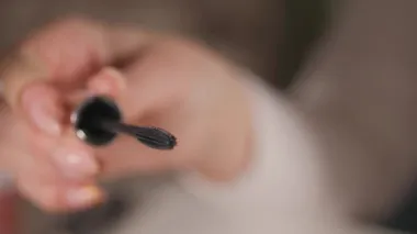 Kirpiklerine siyah rimel sürmek için silikon fırça ellerde dönüyor..