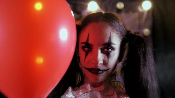 Gemakkelijke Halloween make-up. Meisje met een rode ballon, in de vorm van een clown. — Stockvideo