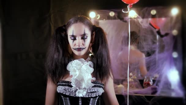 Lehký Halloweenský makeup. Dívka s červeným balónem, ve formě klauna. Koule zmizí a znovu se objeví. — Stock video