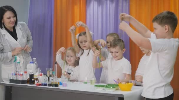 Expériences chimiques pour les enfants. Des enfants tenant dans sa main un long ver vert. La pièce est remplie de fumée artificielle . — Video