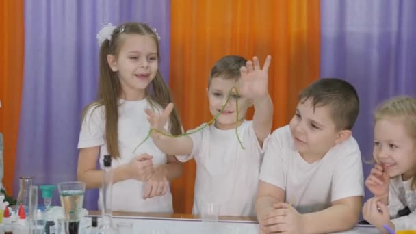 Esperimenti chimici per bambini. Il ragazzo ha in mano un verme verde lungo. La stanza è piena di fumo artificiale . — Video Stock