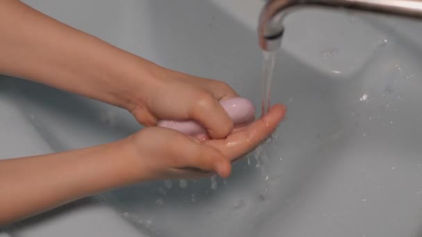Cuidado de las manos. Lávate las manos con agua corriente. El niño se lava las manos con jabón. El chico se lava las manos antes de comer en el baño. El concepto de limpieza e higiene . — Vídeo de stock