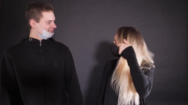 Un tizio con una ragazza con una maschera medica. Un uomo spruzza una donna da un palloncino giallo con del liquido. Spruzzare una soluzione disinfettante. Emozioni violente della gente . — Video Stock