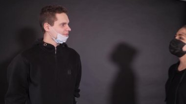 Tıbbi maskeli bir kızla bir adam. Bir adam bir kadına sarı bir balondan sıvı püskürtür. Dezenfektan solüsyonu sıkıyorum. İnsanların vahşi duyguları..