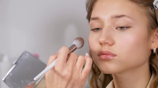 Förbereda modellerna hud för att applicera makeup. Bearbeta ansiktet med en borste med ett puder Foundation appliceras. — Stockvideo