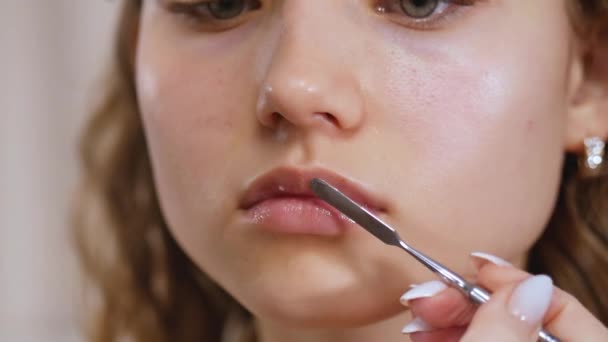 Preparação da pele dos modelos para aplicação de maquiagem. Tratamento labial com espátula e bálsamo labial. Fechar . — Vídeo de Stock