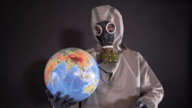 Kimyasal koruma giysisi ve gaz maskeli bir adam. Adam Dünya 'nın bir modelini tutuyor, bir küre. Dünya gezegeninin dezenfekte edilmesi. Dünya 'ya şöyle bir yazı iliştirilmiş bir pankart: QuARANTINE.