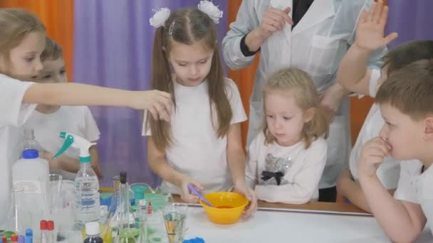 儿童化学实验 加入配料到一个黄色碗里搅拌 孩子们的有趣实验 一个女人在上认知科学课儿童游戏的乐趣 房间里充满了假烟 — 图库视频影像