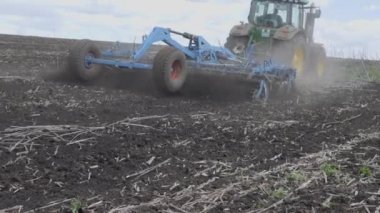Toprağı temizliyorum. Kısa disk harrow. Gökyüzüne karşı bulutlu tarımsal makinelerin çalışması. Genel plan.