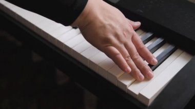 Elektronik piyano. Parmaklar piyano tuşlarına bassın. Piyanonun tüm tuşlarına elin tüm parmaklarını bağlamak. Müzik dersi.