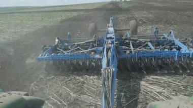 Toprağı temizliyorum. Kısa disk harrow. Bakir topraklarda çalışan çok amaçlı güçlü bir traktör. Kuru ayçiçeği tarlasının işlenmesi. Tarım tarlasını ekime hazırlıyorum. Çernozem topraklarının yetiştirilmesi. Kapatın. Yukarıdan görünüşü.