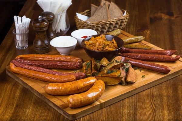 Assortment hot sausages serving on wooden board — Stock Photo, Image