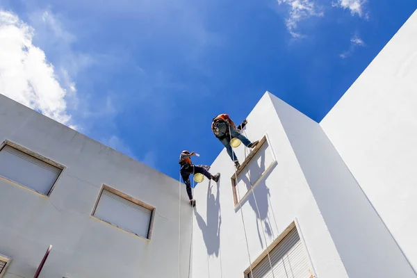 Industrielle Alpinisten arbeiten an weißer Wand — Stockfoto