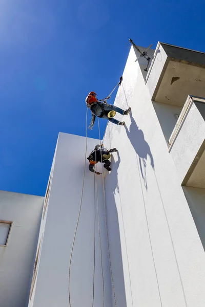 Travail alpiniste industriel sur mur blanc — Photo