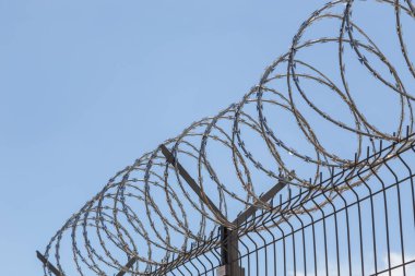 Gökyüzü arka planında dikenli tel