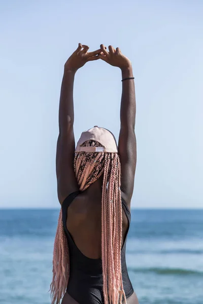 Young girl in a black bathing suit and cap with long pink pigtai — Stock Photo, Image