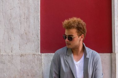 Genç Moda adam sokakta kırmızı duvar arka plan üzerinde
