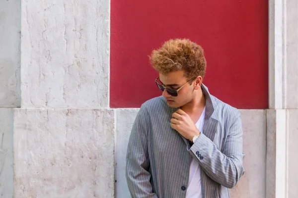 Genç Moda adam sokakta kırmızı duvar arka plan üzerinde