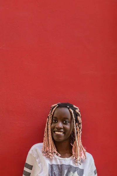 Молодая девушка моды на красном фоне стены на улице — стоковое фото