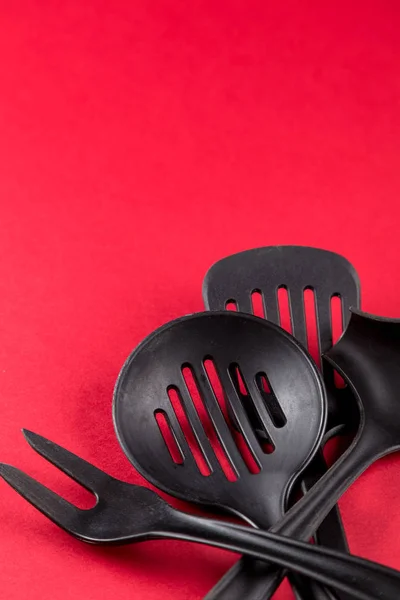 Utensili da cucina domestici usati con graffi su sfondo di carta rossa — Foto Stock