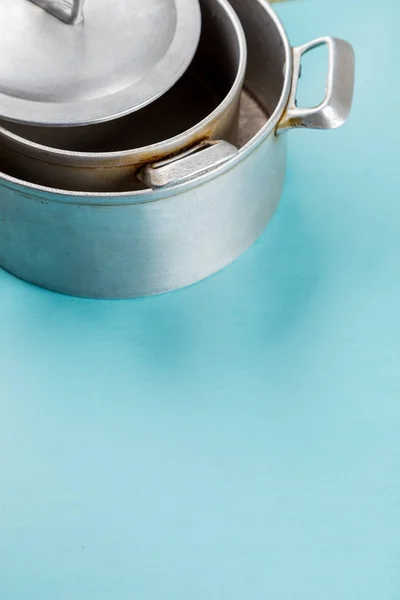 Used home saucepan with scratches on blue paper background — Stock Photo, Image