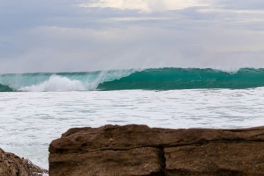 Okyanus kıyısı, köpüklü hareketli dalgalar. 