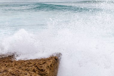 Okyanus kıyısı, köpüklü hareketli dalgalar. 