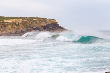 Okyanus kıyısı, köpüklü hareketli dalgalar. 