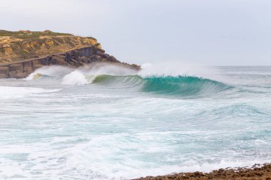Okyanus kıyısı, köpüklü hareketli dalgalar. 